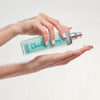 Christine Valmy's all-natural Dermafluide: Cleansing Milk & Makeup Remover held horizontally by hands