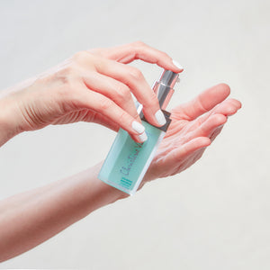 Christine Valmy's all-natural Vita Repair: Skin Replenishing Serum being held vertically by hands