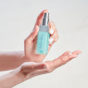 Christine Valmy's all-natural Vitamin C Serum: Antioxidant Revitalizing Formula being held vertically by hands